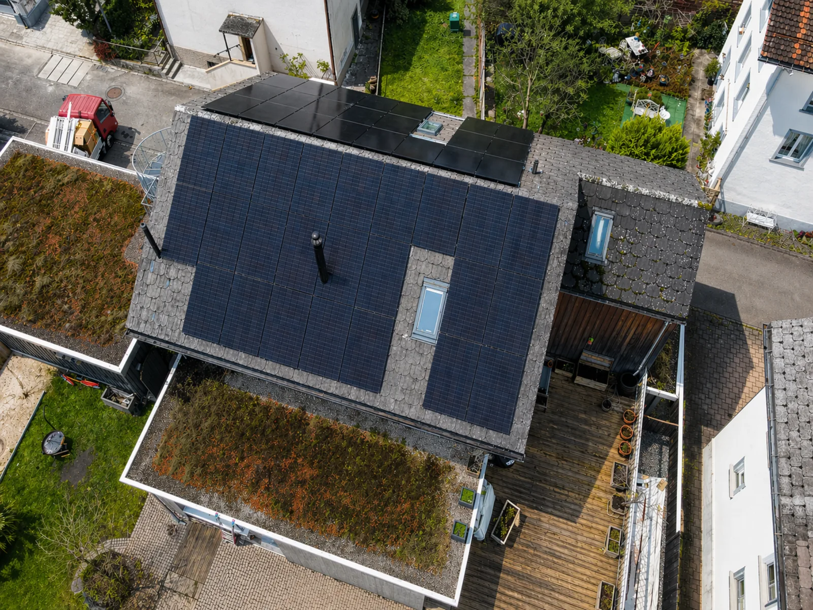Drohnenaufnahme einer grossflächigen Photovoltaikanlage auf einem Wohnhaus